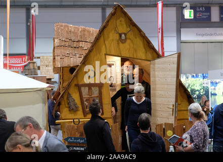 20 November 2019, Sachsen, Leipzig: Besucher auf der Touristik & Caravaning (TC) Messestand in einem Holzhaus im Urlaub in der Bayerischer Wald Region. Am Mittwoch (20.11.2019) die Tore zur größten Reisemesse in Mitteldeutschland für den 30 Mal geöffnet. Bis 24.11.2109 531 Aussteller aus der ganzen Welt werden sich an der TC vorhanden. Partner in diesem Jahr ist die Region Erzgebirge. Foto: Sebastian Willnow/dpa-Zentralbild/dpa Stockfoto