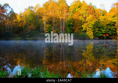 Teich mit Herbst Farbe in der Dämmerung und Reflexionen auf dem Wasser Stockfoto