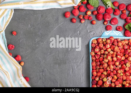 Blau Teller der wilde Erdbeeren mit Beeren und Himbeeren Stockfoto