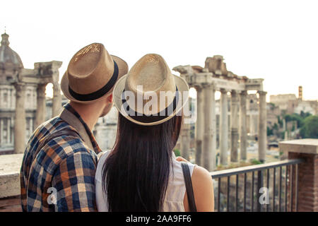 Junges Paar touristische am Forum Romanum suchen bei Sonnenaufgang umarmte. Historische imperial Foro Romano in Rom, Italien ab Panorama Sicht. Stockfoto