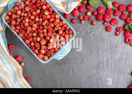 Blau Teller der wilde Erdbeeren mit Beeren und Himbeeren Stockfoto