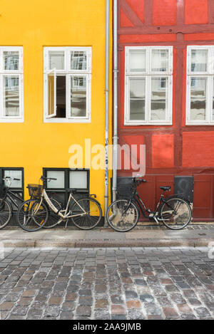 Fahrradstadt Kopenhagen, Blick auf Fahrräder, die an farbenfrohen Gebäuden in einer Straße in der Altstadt von Kopenhagen, Dänemark, geparkt sind. Stockfoto