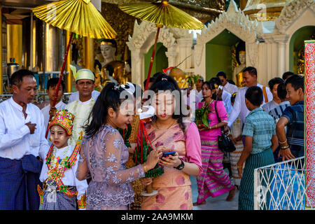 Junge Menschen und ihre Familien in einem Novitiation/Shinbyu Zeremonie an der Shwedagon Pagode, Yangon, Myanmar. Stockfoto