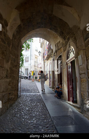 Die Menschen gehen durch die almedina Torbogen in der Altstadt von Coimbra Portugal Stockfoto