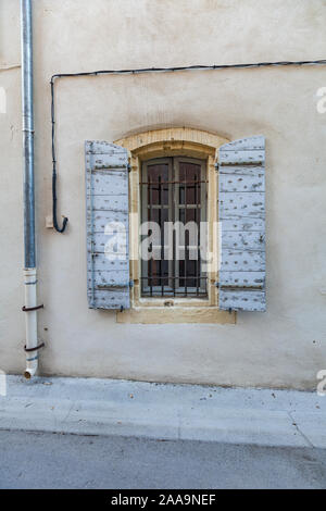 Fenster eines Hauses auf einer Straße in der Altstadt von Arles, im Süden von Frankreich. Mit blau lackierten traditionellen Fensterläden aus Holz. Stockfoto