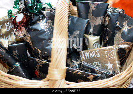 Viele kleine Pakete mit Geschenken in Fancy Papier für die Deutschen Adventszeit in einem Korb Stockfoto