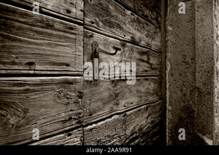 Eine hölzerne Tür mit einem Bügeleisen auf einen Stein rahmen Griff Stockfoto