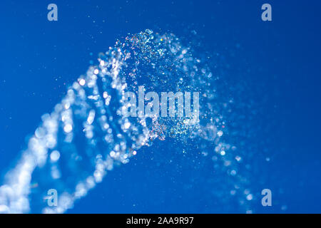 Wasserstrahl mit Spritzer auf dem Hintergrund des blauen Himmels. Selektive flachen konzentrieren. Bewegungsunschärfe. Stockfoto