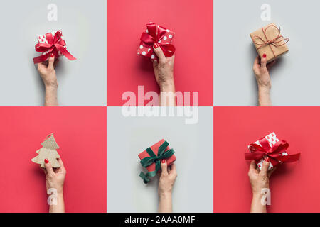 Weibliche Hände halten verschiedene Geschenke und Weihnachtsbaum auf Grau. Weihnachten Grußkarte. Happy Boxing Day. Stockfoto