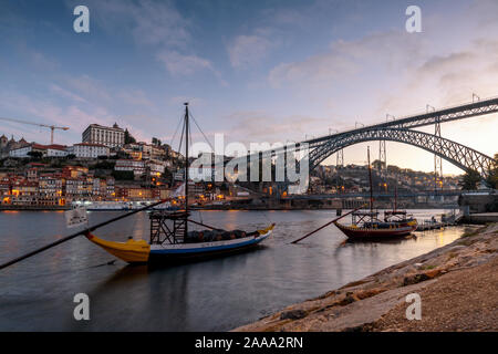 Rabelo traditionelle Boote für Wein Transport auf dem Fluss Douro. In Vila Nova de Gaia, mit Dom Luís I Brücke und Altstadt Skyline im Hintergrund. Stockfoto