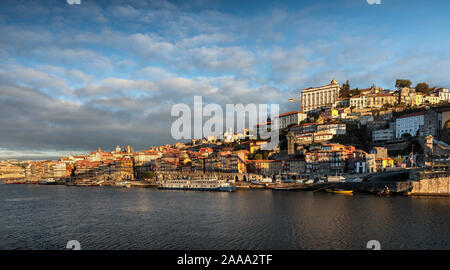 Blick auf Porto Altstadt Skyline aus über den Fluss Douro. In den frühen Morgenstunden Sonnenlicht getaucht. Stockfoto