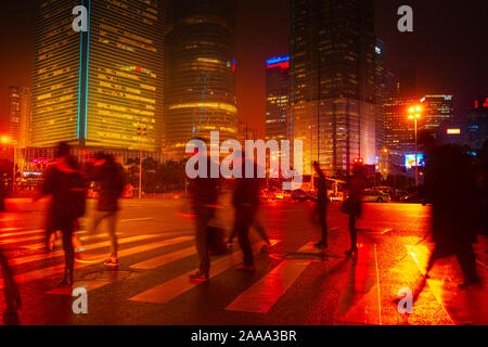 Zusammenfassung Hintergrund von Leuten über den Zebrastreifen in der Nacht in Shanghai, China. Perfektes Hintergrundbild von unscharfen night street mit unkenntlich p Stockfoto