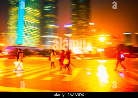 Zusammenfassung Hintergrund von Leuten über den Zebrastreifen in der Nacht in Shanghai, China. Perfektes Hintergrundbild von unscharfen night street mit unkenntlich p Stockfoto
