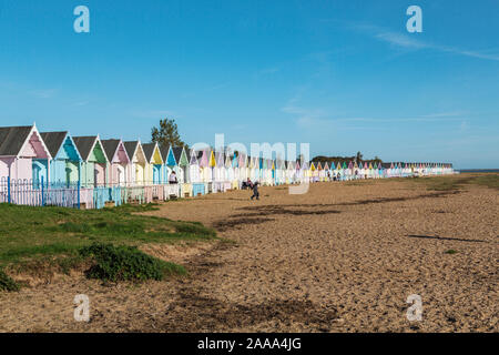 Eine Reihe von pastellfarbenen Holzhütten am West Mersea. Mersea Island, Essex, Vereinigtes Königreich. Stockfoto