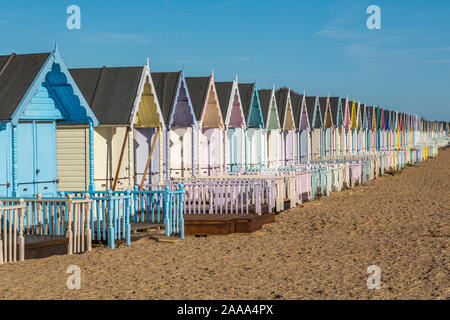 Eine Reihe von pastellfarbenen Holzhütten am West Mersea. Mersea Island, Essex, Vereinigtes Königreich. Stockfoto