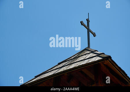 Kreuz auf einem kleinen hölzernen Turm gegen den blauen Himmel Stockfoto