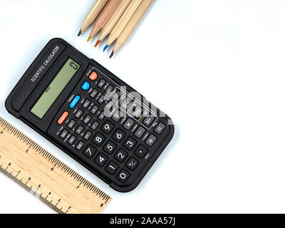 Wissenschaftlicher Taschenrechner mit Holzlineal & Holzstiften mit farbigen Spitzen. Kopieren Sie den Platz rechts auf einen weißen Hintergrund. Stockfoto