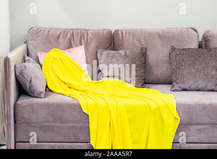 Weiches Sofa. Gelbe Decke. Weiche Kissen. Stockfoto