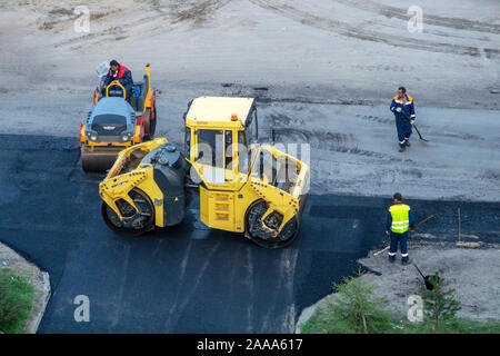 Die Straßenarbeiter legen Asphalt Stockfoto