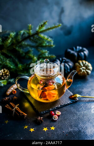 Tee in eine Kanne. Eine Infusion von Kurkuma, Ingwer und Cranberry. Weihnachten herbst Atmosphäre. Schwarzen Hintergrund. Stockfoto