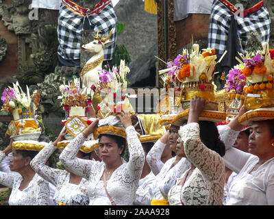 In Ubud, Indonesien - März, 14, 2018: balinesische Frauen tragen Angebote auf ihre Köpfe an einem Tempel in Ubud Stockfoto