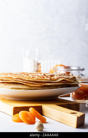 Dünne Pfannkuchen auf weißem rustikalen Tisch, Zutaten, Blini, heimische Küche und Crepes Stockfoto