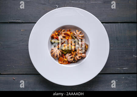 Ansicht von oben Vegetarische Paella mit Oktopus auf einem weißen Teller. Mediterrane Speisen. Ketogenic Diät Rezepte Stockfoto