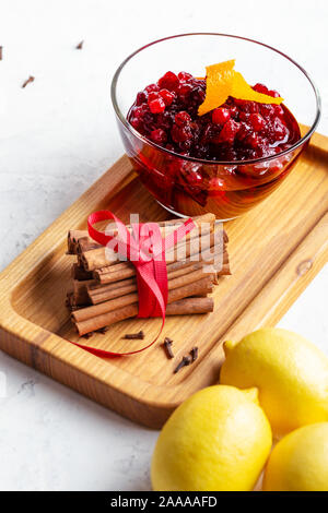 Thanksgiving cranberry Sauce im Glas Schale mit frischem Obst Orange und Zitrone bereit zu an Stockfoto