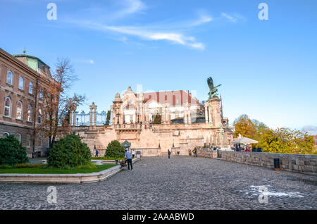 Budapest, Ungarn - Nov 6, 2019: historischen Innenhof der Burg von Buda. Statue des mythologischen Vogel Turul und historische Treppe im Hintergrund. Touristische Sehenswürdigkeit, Menschen auf dem Platz. Stockfoto