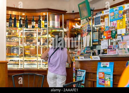 Ein weiblicher Kunde kauft Lottery Tickets zu einem tabacchi Shop in der ligurischen Stadt Ruse, Italien Stockfoto