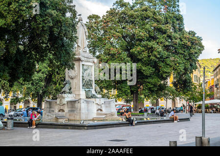 Lokale französische Männer und Frauen am Brunnen und die Statue in Place Garibaldi im Zentrum von Nizza, Frankreich entspannen, an der Französischen Riviera Stockfoto