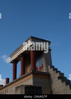 Gebäude mit Rostfarbenen Säulen und ein Fresko mit einem wütenden Stier und Olivenbaum im Eingang Nord der Minoer Palast von Knossos, Kreta Stockfoto