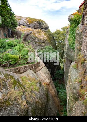 Terrassenförmig angelegten Garten, der von einem log Zaun auf einem Sandstein und Konglomeraten Hügel mit ähnlichen Klippen angrenzenden und gegenüber umgeben. Am Heiligen M fotografiert. Stockfoto
