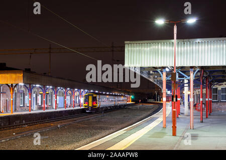 Abellio East Midlands railway Klasse 158 Sprinter Zug in Stockport Bahnhof bei Nacht mit ein Peterborough Liverpool - Zug Stockfoto