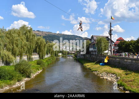 Zip Line im Herzen von Vatra Dornei mountain Four Seasons über die dorna River Resort. Outdoor touristische Aktivität in Suceava. Zip Line über den Fluss Stockfoto