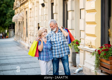 Gerne älteres Paar mit Einkaufstüten. Senior Paar umarmen Stockfoto