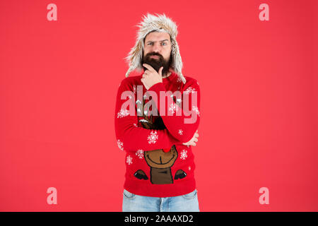 Harte Entscheidung. Die Entscheidungsfindung. Zu Weihnachten wünschen. Lebensverändernde Entscheidung. Hipster bärtiger Mann tragen winter Pullover und Hut. Frohes neues Jahr. Winter party Outfit. Man nachdenkliche Gesichtsausdruck. Stockfoto