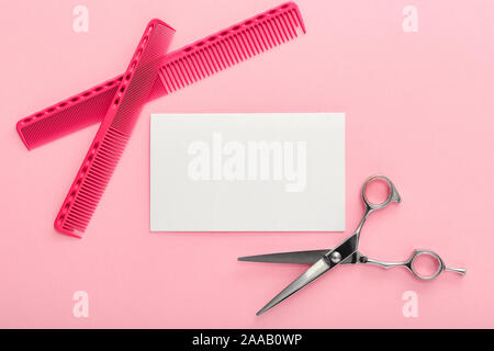 Friseur. Scheren, Kämme und Accessoires anderer Friseur und Ausrichtung des blonden Haares auf rosa Hintergrund. Mockup für gift card. Flach mit Stockfoto