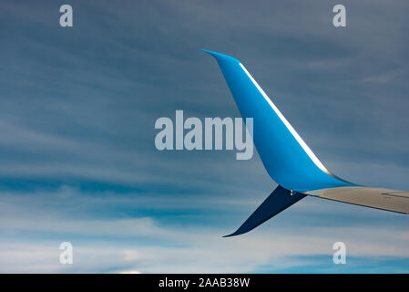 Flugzeugflügel. Blue Wing Tipp des Flugzeugs gegen den blauen Himmel mit Wolken. Stockfoto