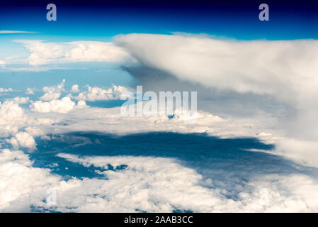 Groß und flauschige Wolken, Ansicht von oben. Kaskaden von weißen Wolken im blauen Himmel haze. Wolken, Berge. Stockfoto