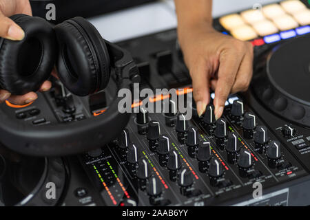 Hände von DJ Mixing Titel auf Professional Sound Mixer. Modische Ringe am Finger des Mädchens Discjockey Musik. Closeup, Knöpfe und Regler in Stockfoto
