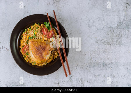 Gebratene Nudeln und Reis Huhn mit Petersilie und Tomaten mit Stäbchen Stockfoto