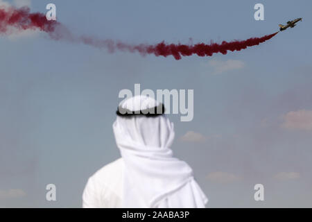 Dubai, Vereinigte Arabische Emirate. Nov, 2019 18. Ein Mann in einem thawb beobachten ein Al Fursan aerobatic Team Flight Display gekleidet, während der zweite Tag des Dubai International Airshow 2019. Credit: SOPA Images Limited/Alamy leben Nachrichten Stockfoto