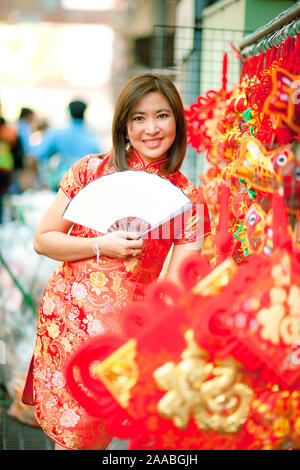 Asiatische Frau mit der chinesischen Tradition Kleidung mit chinesischen Bambus Ventilator lächelndes Gesicht in yaowarat street Chinatown von Bangkok Thailand Stockfoto