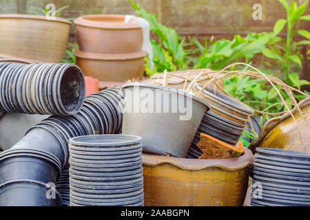 Stapel Töpfe mit vielen alten Pflanzen, die nicht in Verwendung vor dem orchid Zucht Garten sind. Stockfoto