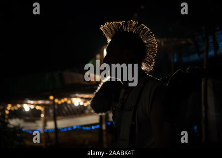 Silhouette einer Punk mit einem Mohawk in der Dunkelheit im Hintergrund Licht, Nacht Musik Party Stockfoto