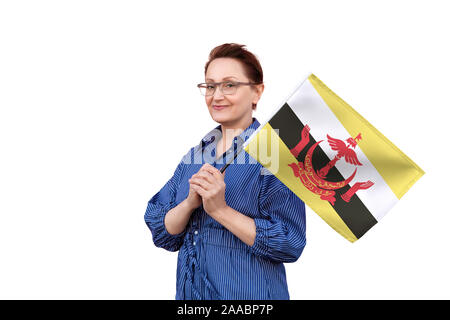 Brunei Fahne. Frau mit Brunei Flagge. Schönes Portrait der Dame im mittleren Alter 40 50 Jahre alt, eine große Flagge mit weissem Hintergrund. Stockfoto