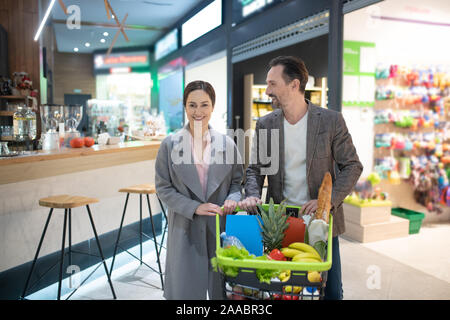 Gut aussehendes paar Geschäftsleute verlassen Supermarkt am Abend Stockfoto