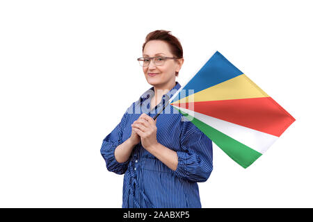 Seychellen Fahne. Frau mit Seychellen Flagge. Schönes Portrait der Dame im mittleren Alter 40 50 Jahre alt, eine große Flagge mit weissem Hintergrund. Stockfoto