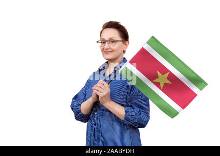 Flagge Suriname. Frau mit Flagge Suriname. Schönes Portrait der Dame im mittleren Alter 40 50 Jahre alt, eine große Flagge mit weissem Hintergrund. Stockfoto